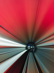 High speed curved motion to the right inside a tunnel with red light.