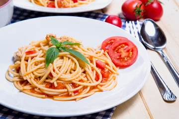Spaghetti pasta with and tomato sauce on wood background