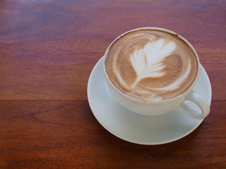 Hot coffee latte on a wooden table.