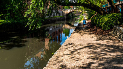 Fototapeta na wymiar Woman walking down canal toepath in Georgetown, DC