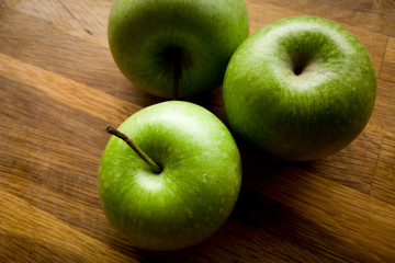 green organic apples on wooden table