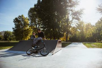 Father and son sitting on a skate ramp and talking