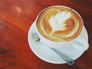 Hot coffee latte on a wooden table.