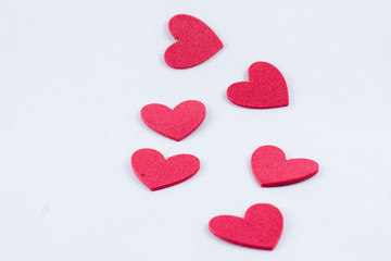 Red crafting foam hearts in white background. Decor hearts by cutting from red crafting foam