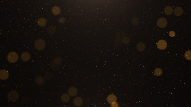Abstract background of flickering gold particles and light flare