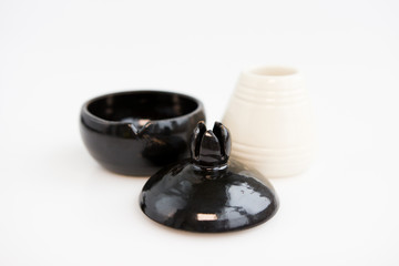 Obraz na płótnie Canvas white and black vases. white conical vase and black pomegranate on white background. handwork. author ceramics