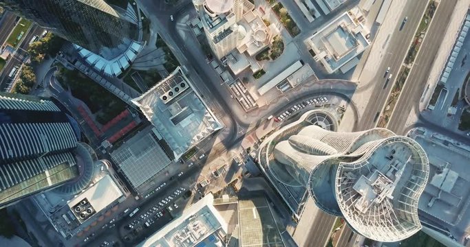 Down-looking aerial view of a global futuristic city, with skyscrapers, high rise towers and big avenues, circulation and cars, in Doha, the capital city of Qatar