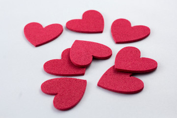 Red crafting foam hearts in white background. Decor hearts by cutting from red crafting foam