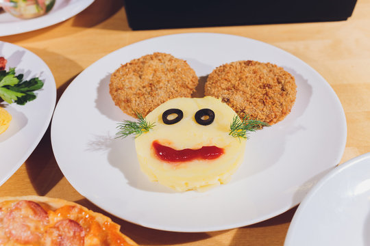Child food. Funny food. Plate with cutlets and mashed potatoes in the form of a monkey faces. Children's menu.