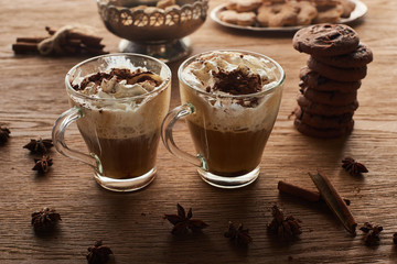 Christmas cacao on wooden table with anise, cinnamon and cookies