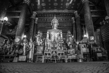 Luang Prabang, Laos »; August 2017: Golden sculptures inside the temple of Wat Xieng Thong in Luang Prabang, black and white photo