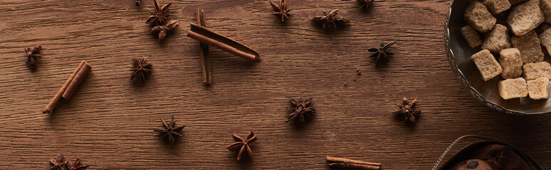 top view of brown sugar, anise and cinnamon on wooden table, panoramic shot