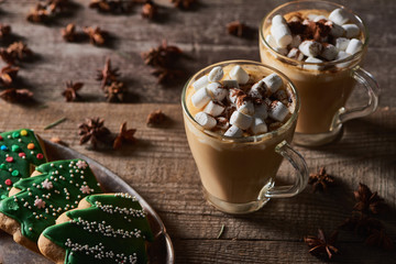 cacao with marshmallow on wooden table with anise and Christmas cookies