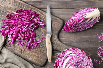 Fresh cabbage with cutting board and knife on wooden table