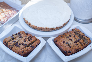 Plates of banana nut bread and cheese pie arranged on a table.