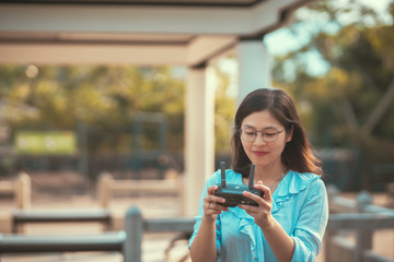 Young happy woman play drone with drone controller on hand