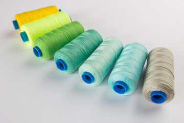 sewing thread mixed colors polyester spools on a white background