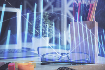 Financial chart hologram with glasses on the table background. Concept of business. Double exposure.