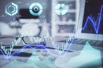 Financial chart hologram with glasses on the table background. Concept of business. Double exposure.