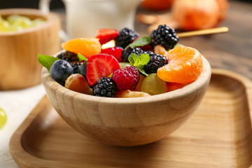 Bowl with tasty fruit salad on table