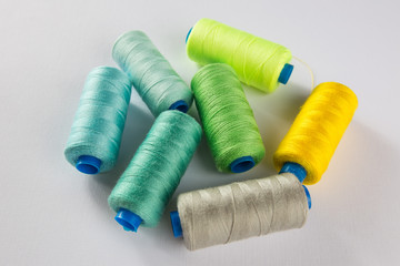 sewing thread mixed colors polyester spools on a white background