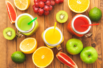 Composition with fresh juice and fruits on wooden table