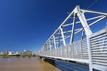 増水した台風一過の翌朝の江戸川と鉄橋風景