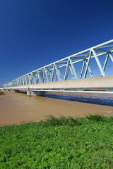 増水した台風一過の翌朝の江戸川とつくばエクスプレスの鉄橋風景