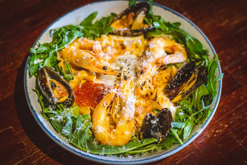 Pink sauce pasta (a mixture of Pomodoro and Carbonara), Grated Parmesan, Extra Virgin Olive Oil, Arugula, Sous Vide Egg, Calamari, Black Lump Fish Caviar, Black Truffle Pate, Prawns