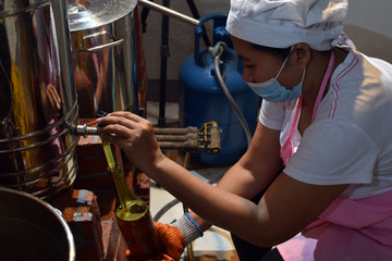 Woman pouring fermented alcoholic juice in wine bottle in a home based winery. side view shot