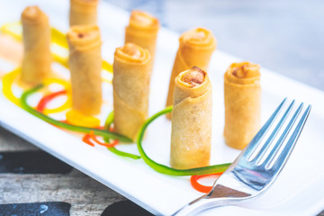 crab spring rolls cut into halves and served on a white china porcelain plate