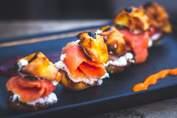 Delicias De Salmon with smoked salmon, Cream cheese, capers, profiteroles rellenos