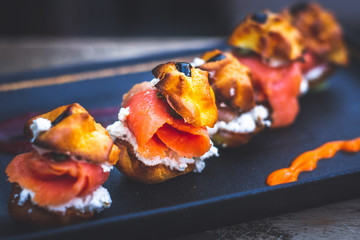 Delicias De Salmon with smoked salmon, Cream cheese, capers, profiteroles rellenos