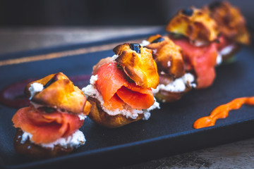 Delicias De Salmon with smoked salmon, Cream cheese, capers, profiteroles rellenos