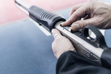 Hände laden eine Waffe Pumpgun mit Munition