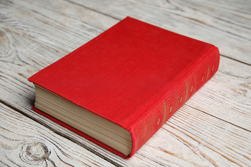 Hardcover book on light wooden  table. Space for text