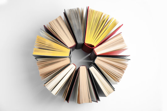 Circle made of hardcover books on white background, flat lay