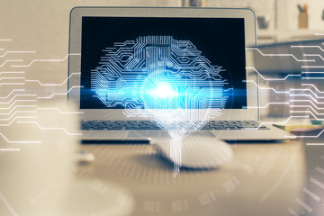 Double exposure of table with computer and brain hologram. Data innovation concept.