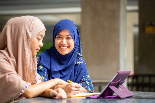 Two asian musalim working and discuss with tablet