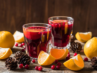 Traditional Christmas drink. Christmas hot mulled wine with oranges, cranberries and spices on a wooden table