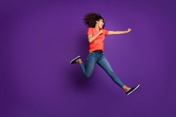 Full length body size turned photo of running jumping girlfriend kicking empty space with her fist...