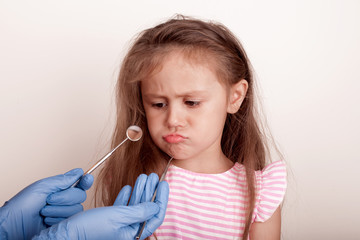 Dental medicine and healthcare - dentist examining little child girl patient open mouth showing caries teeth decay