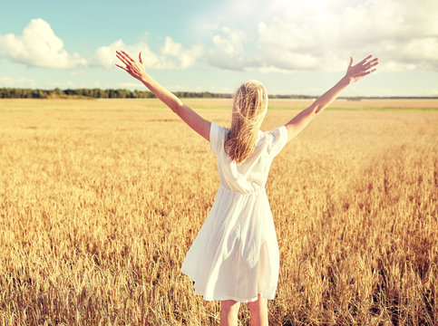country, nature, summer holidays, vacation and people concept - happy young woman in white dress on cereal field