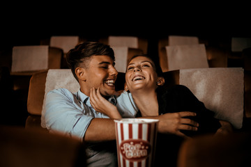 Couple watch movie in theater with popcorn smile and happy face