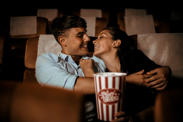 Couple watch movie in theater with popcorn smile and happy face
