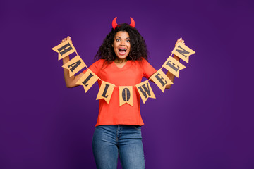 Photo of cheerful positive cute pretty nice girlfriend holding chain of flags forming halloween expressing excited emotions wearing jeans denim isolated violet vivid color background