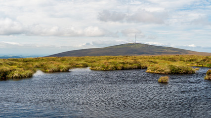 Lake landscape at the top of Tonduff Mountain in Wicklow, Ireland. Accumulated rain water forming a pond surrounded by blanket bog.