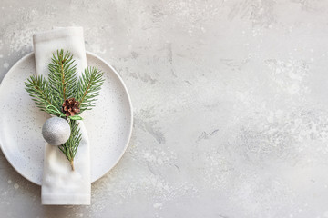 Christmas or New Year table setting with festive decorations on light grey background with copy space. Holidays background. Top view, flat lay.