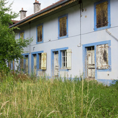 Fototapeta na wymiar Un bâtiment ouvrier abandonné. Le passé industriel en Europe. Une ancienne résidence pour ouvriers en France. Un bâtiment bleu.