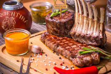 Steak on a wooden Board with sauces and rosemary
